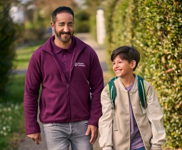 Betreuungskraft begleitet Kind zur Schule